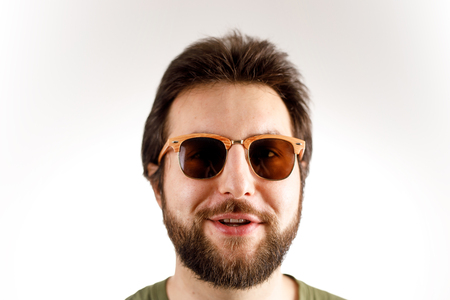 A man in sunglasses and a green shirt is smiling at the camera.の写真素材
