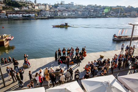 Porto, Portugal - November 13, 2018: Musical group on the embankment of Porto, Portugal. Listeners...