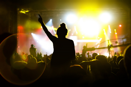 Man with hands up against a music festival scene.の写真素材