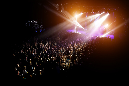 People with their hands up at a concert of their favorite group. Crowd watching a showの写真素材