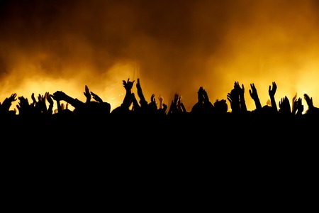 Raised hands in honor of a musical show on stage, People in the hallの写真素材