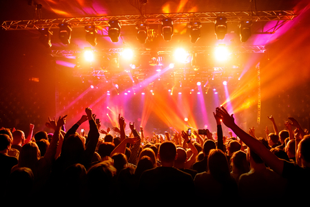 Raised hands in honor of a musical show on stage, People in the hallの写真素材
