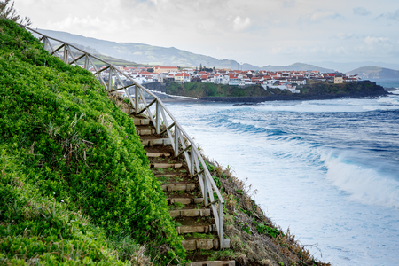 Hiking along the shore of the ocean, Stairs and background of cityの写真素材