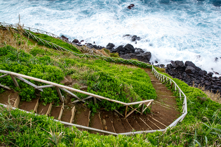 Walking trail along the sea, ladder with railing on the background of wavesの写真素材