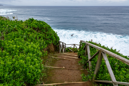 Walking trail along the sea, ladder with railing on the background of wavesの写真素材