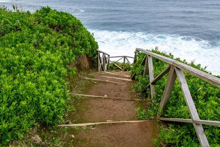 Walking trail along the sea, ladder with railing on the background of wavesの写真素材