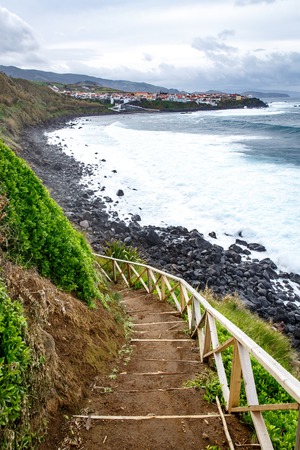 Hiking along the shore of the ocean, Stairs and background of cityの写真素材