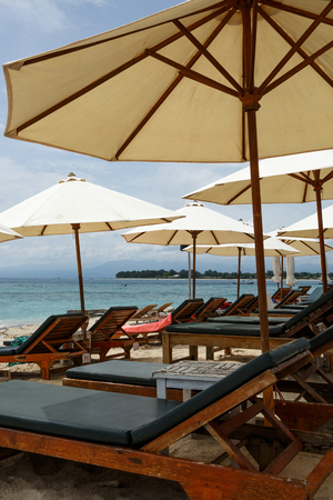 Beach umbrellas with sun beds on the beachの写真素材
