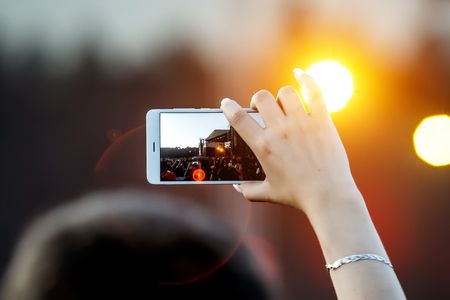 Smartphone in hand record outdoor music show.の写真素材