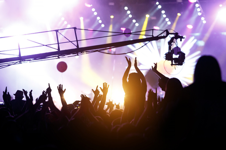 People silhouettes with raised hands at outdoor music showの写真素材