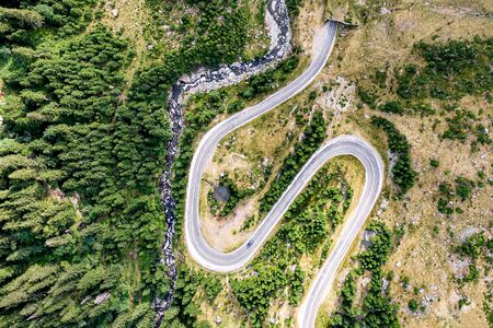 Winding road in the mountains. Forest and river nearby. Transfagarasan road in Trasnylvania, Romania, Europe.の写真素材
