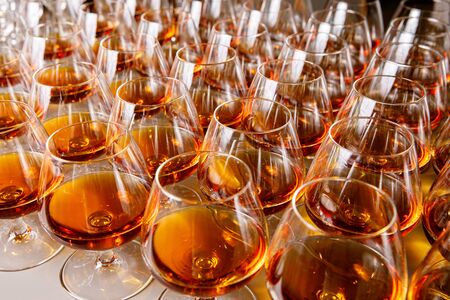 Stylish glasses with cognac or whiskey on table at event catering.の写真素材