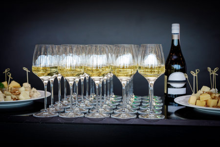 A lot of wine glasses with a cool delicious champagne or white wine at the bar or event catering. Alcohol background.の写真素材