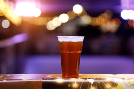 Glass of beer on concert lights backgroundの写真素材
