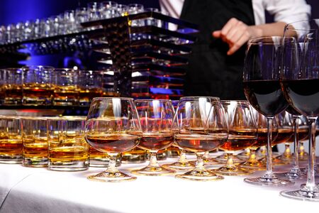 A row with glasses of alcoholic drinks at the partyの写真素材
