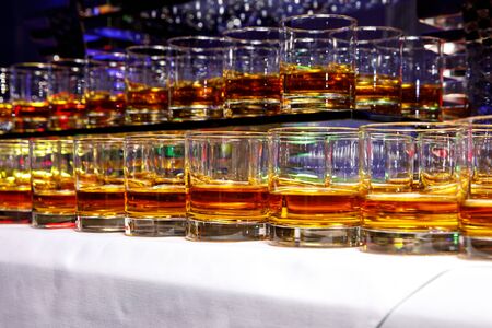 A row with glasses of alcoholic drinks at the partyの写真素材