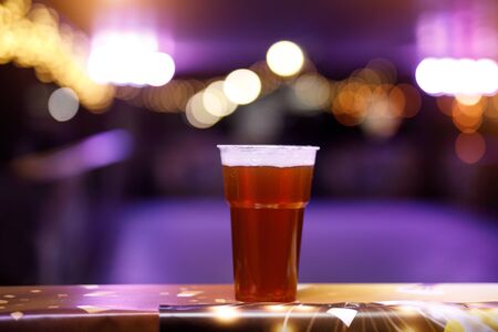 Glass of beer on concert lights backgroundの写真素材