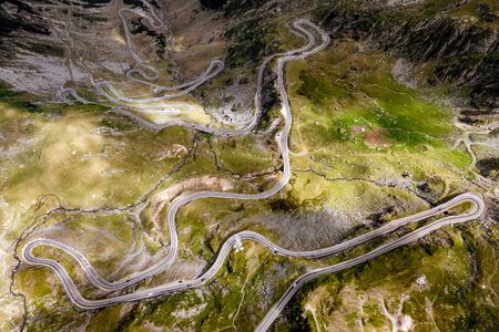 Aerial top view of serpentine narrow road. A road full of twists and turns winding. Romaniaの写真素材