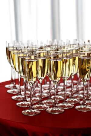Glasses of champagne in a row on a tableの写真素材