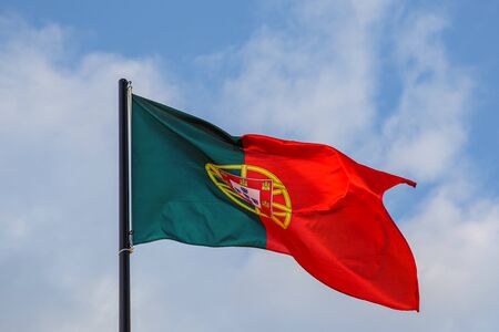 Portuguese flag waving in front of a blue skyの写真素材