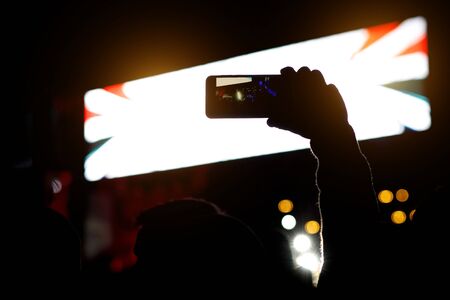 Smartphone silhouette in hands at a music show. Shooting of stageの写真素材