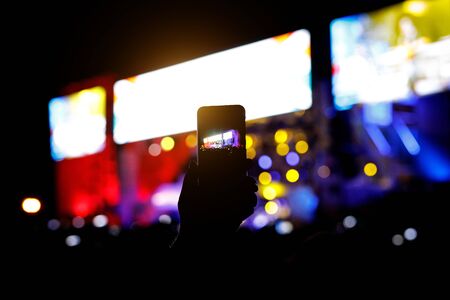 Smartphone silhouette in hands at a music show. Shooting of stageの写真素材