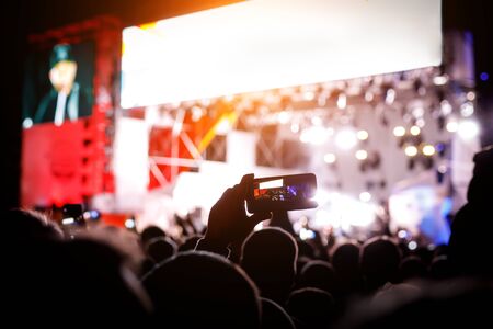 Smartphone silhouette in hands at a music show. Shooting of stageの写真素材