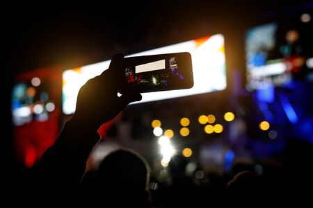 Smartphone silhouette in hands at a music show. Shooting of stageの写真素材