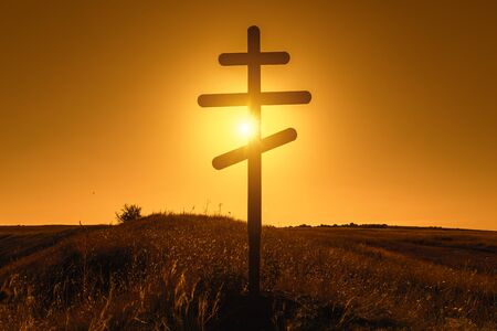 Silhouette of Christian Orthodox cross on sunsetの写真素材
