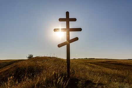 Silhouette of Christian Orthodox cross on sunsetの写真素材