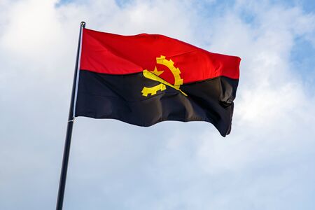Angola flag waving in front of a blue skyの写真素材