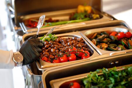 Food on event catering. Hand of the waiter in black gloves in the frameの写真素材