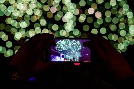 Smartphone shoots fireworks at a festive event.の写真素材