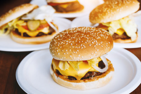 Ready tasty burgers on a round white platesの写真素材