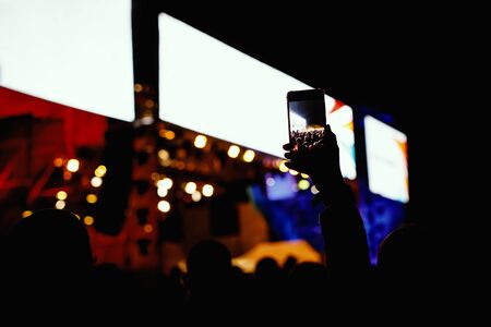 People with mobile phone in hands shooting concert event.の写真素材
