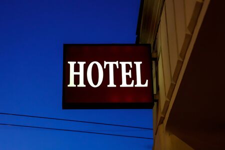 Illuminated sign "hotel" on the street.の写真素材