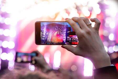 Hand with a smartphone records live music festival, live concert, live concert.の写真素材
