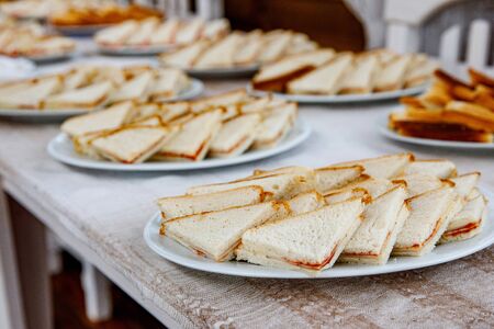 Plates with triangle sandwiches on event cateringの写真素材