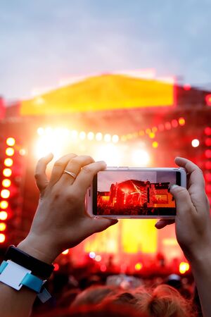 Hands with a smartphone records live music festival, live concert, live concert.の写真素材