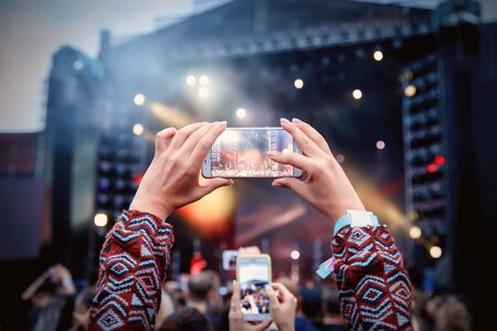 Smartphone over the crowd at a music concert. Record light showの写真素材