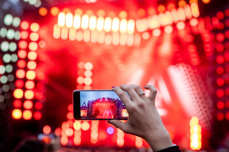 Hand with a smartphone records live music festival, live concert, live concert.