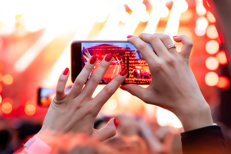 Hand with a smartphone records live music festival, live concert, live concert.