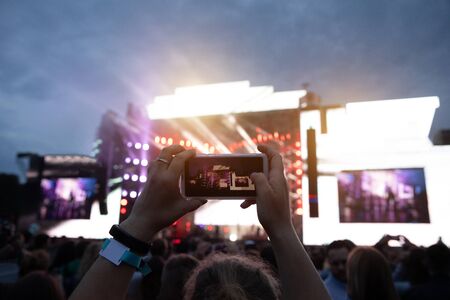 Close up of photographing with smartphone during a concertの写真素材