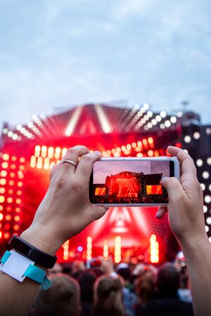 Close up of photographing with smartphone during a concertの写真素材