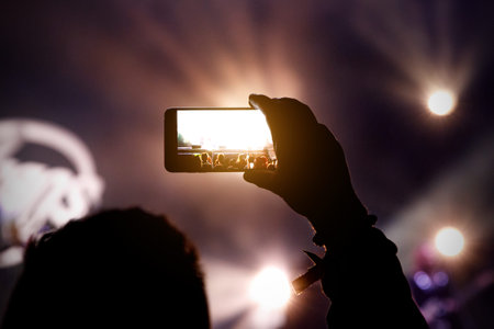 Smartphone in hands of fan during music show