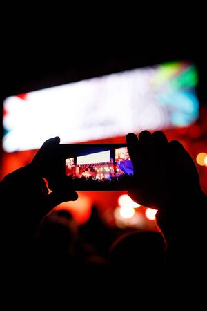 Silhouette of using a mobile phone at a concertの写真素材