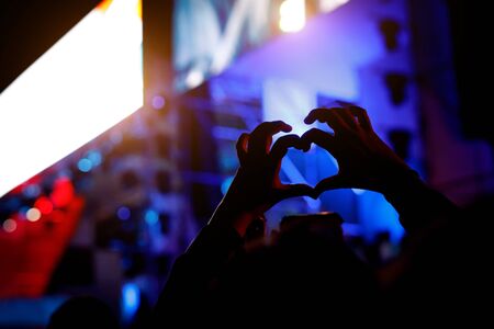 Heart shaped hands at concert, loving the artist and the festival.の写真素材