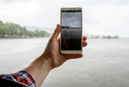 Using smartphone at rainy weather, drops on the screen