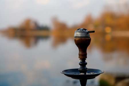 Top of hookah on nature. Sunset time and lake on background