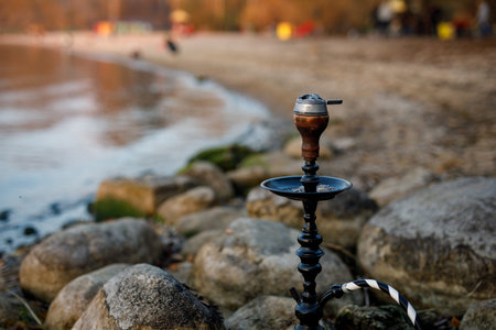 Top of hookah on nature. Sunset time and lake on background